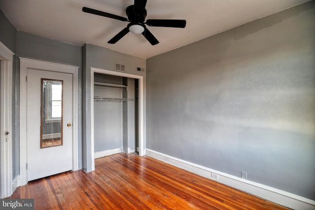 unfurnished bedroom with hardwood / wood-style floors, ceiling fan, and a closet