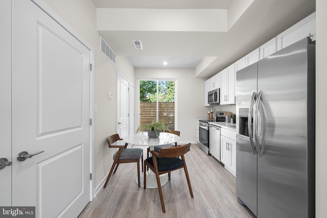 kitchen featuring appliances with stainless steel finishes, light wood-type flooring, and white cabinetry