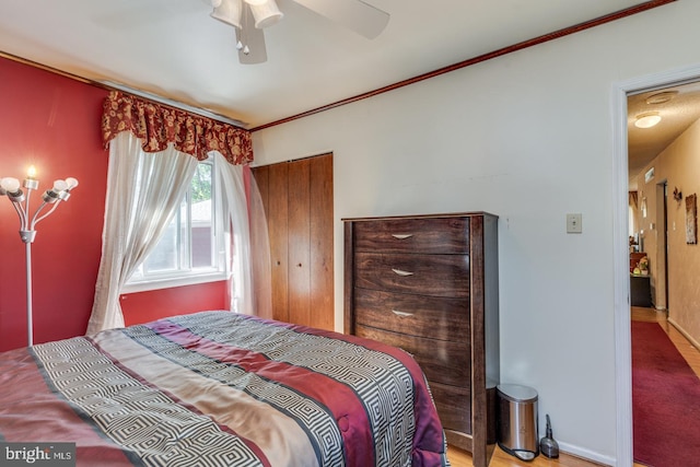 bedroom featuring a closet, ceiling fan, and ornamental molding