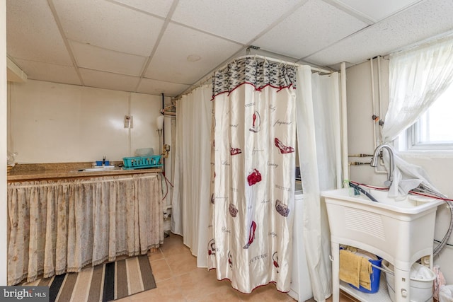 bathroom featuring tile patterned flooring and a drop ceiling