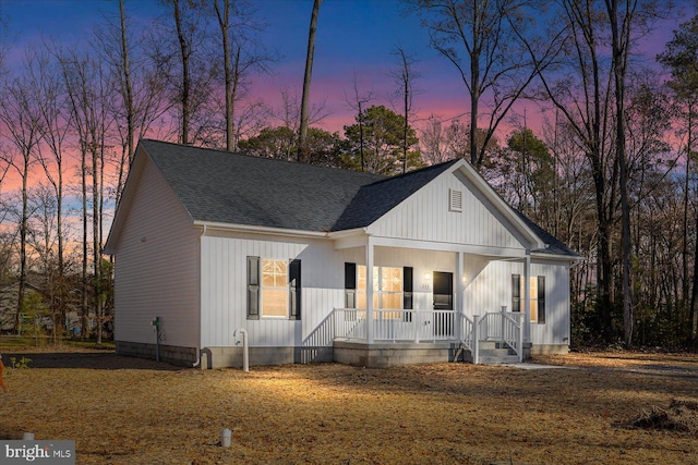 modern farmhouse style home featuring a porch and roof with shingles