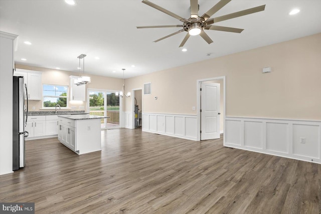 kitchen with a kitchen island, stainless steel fridge, dark hardwood / wood-style flooring, hanging light fixtures, and white cabinetry