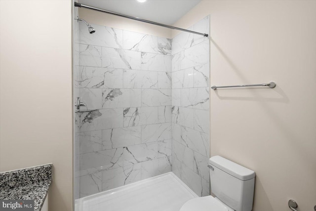 bathroom featuring a tile shower and toilet