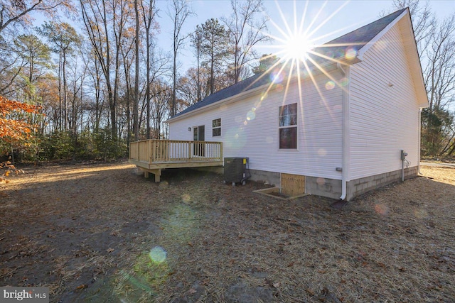 view of home's exterior with a wooden deck and central AC