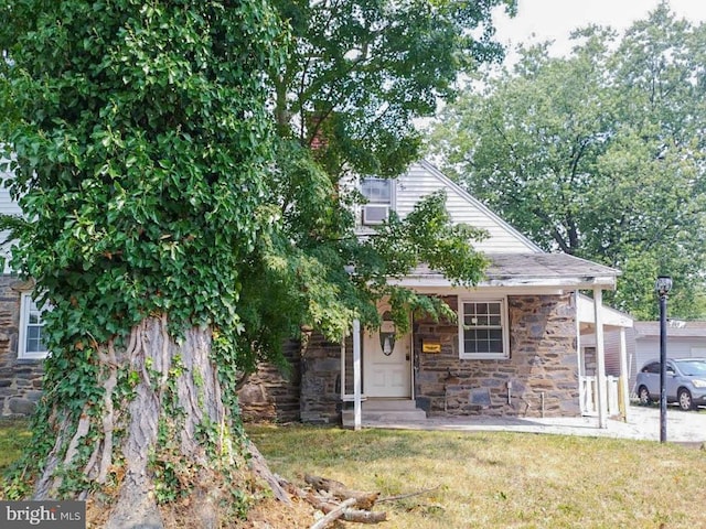 view of property hidden behind natural elements featuring a front lawn