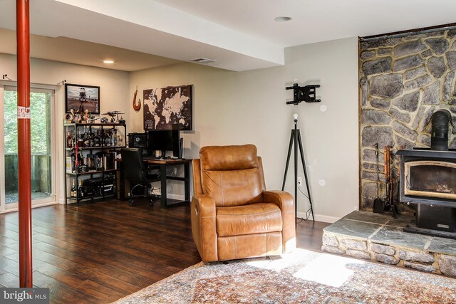 living room featuring dark hardwood / wood-style floors and a wood stove