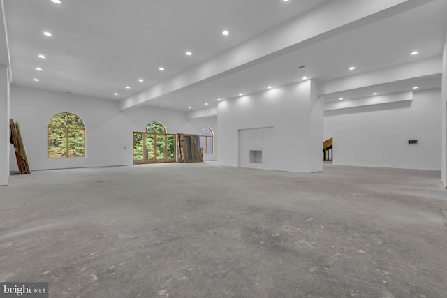 empty room with a fireplace and beam ceiling