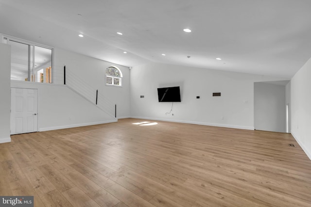 unfurnished living room with lofted ceiling, light hardwood / wood-style floors, and a healthy amount of sunlight