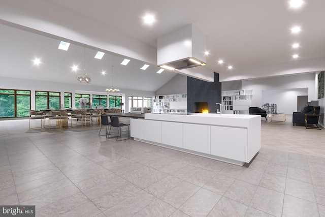 kitchen featuring white cabinets, high vaulted ceiling, an inviting chandelier, and a spacious island