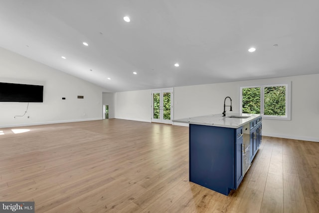 kitchen with blue cabinetry, light wood-type flooring, plenty of natural light, and vaulted ceiling