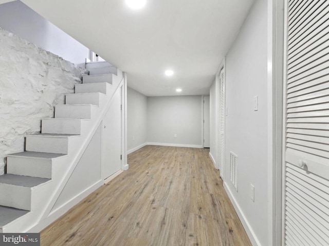 basement with light hardwood / wood-style flooring