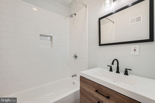 bathroom with vanity and tiled shower / bath