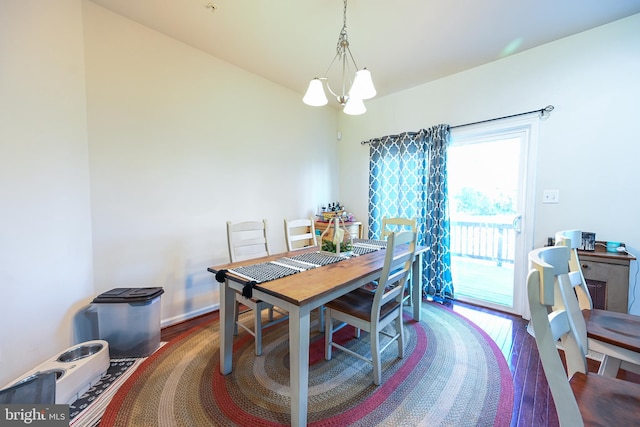 dining area with dark hardwood / wood-style flooring and an inviting chandelier