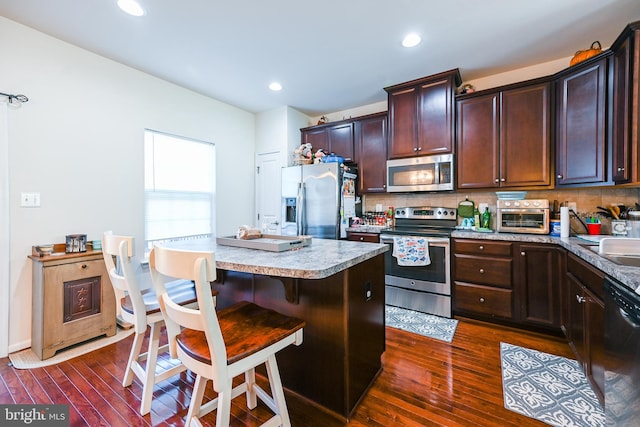 kitchen featuring a center island, stainless steel appliances, backsplash, and dark hardwood / wood-style flooring