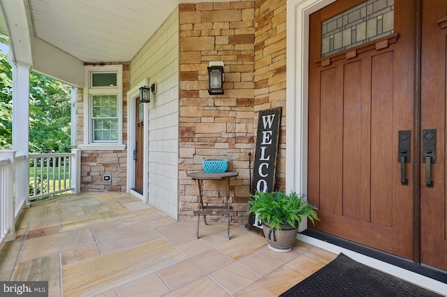 view of exterior entry featuring covered porch