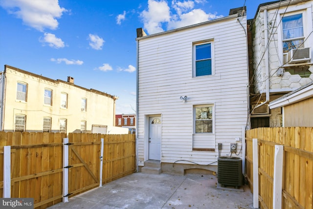 back of property with central air condition unit and a patio