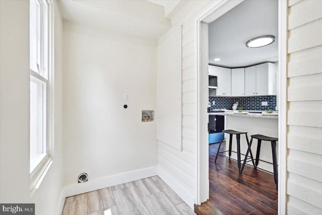 laundry room featuring hookup for a washing machine, electric dryer hookup, and hardwood / wood-style flooring