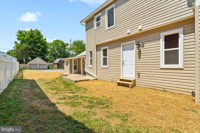 back of house featuring a garage and a yard