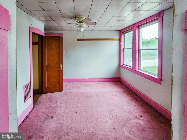 carpeted spare room featuring ceiling fan and a paneled ceiling