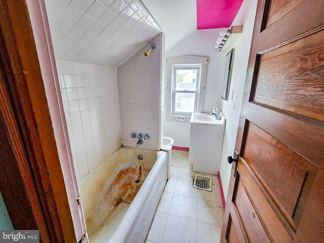 bathroom featuring tile patterned flooring, tiled shower / bath combo, and vanity