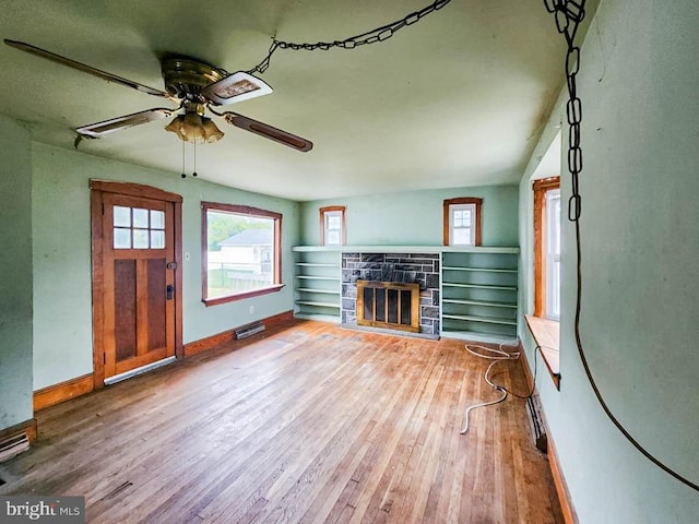 unfurnished living room featuring a fireplace, hardwood / wood-style floors, and ceiling fan