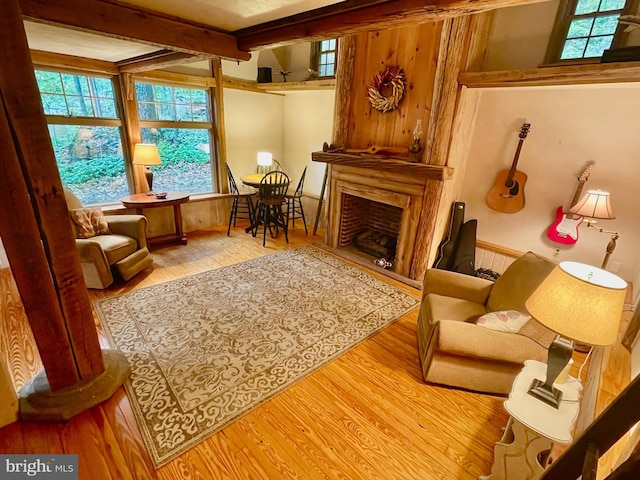 living area with light hardwood / wood-style floors and beam ceiling