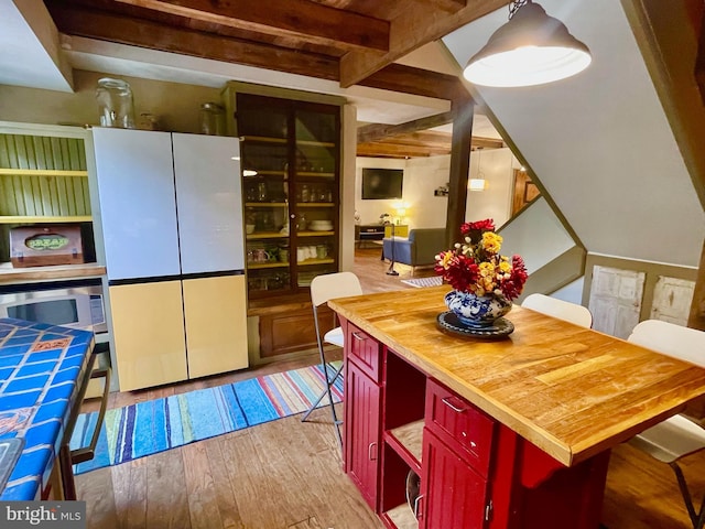 dining room featuring light hardwood / wood-style floors and beam ceiling