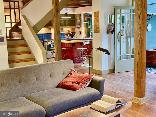 living room with light wood-type flooring and beam ceiling