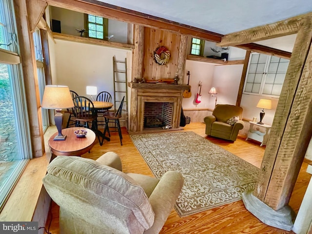 sitting room featuring a towering ceiling, beam ceiling, and light wood-type flooring