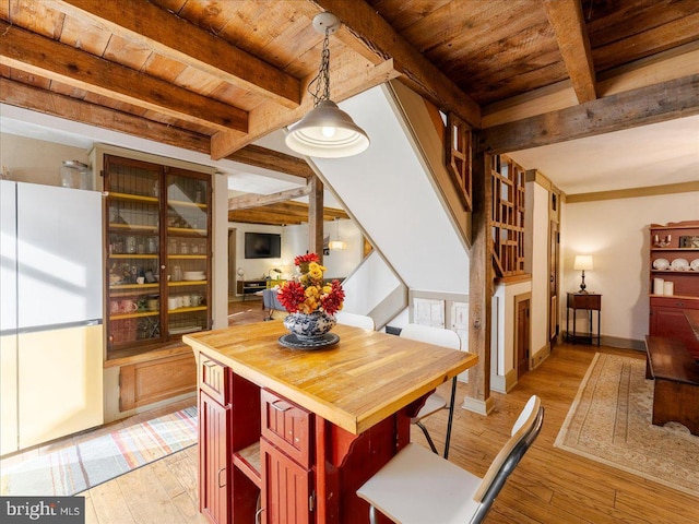 dining area featuring wooden ceiling, light hardwood / wood-style floors, and beam ceiling