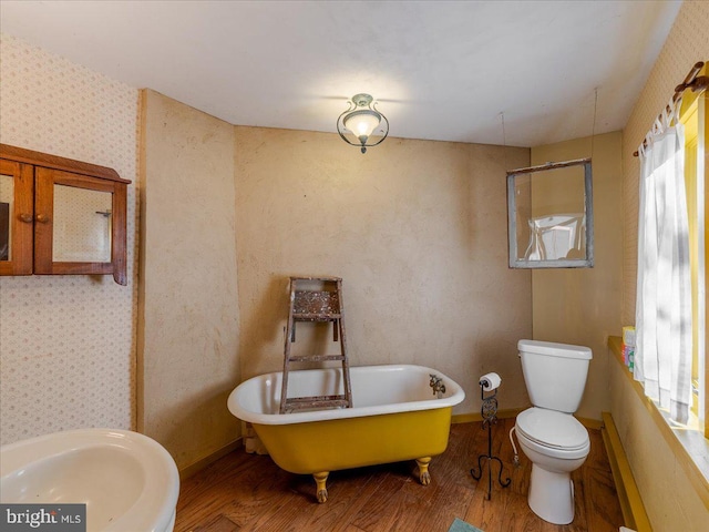 bathroom with toilet, hardwood / wood-style floors, sink, and a tub