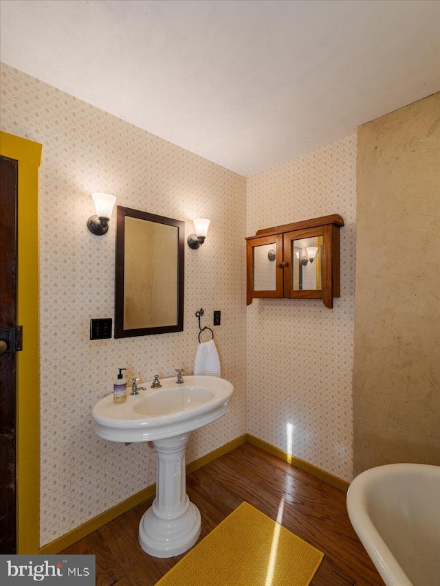 bathroom featuring a bathtub, wood-type flooring, and sink