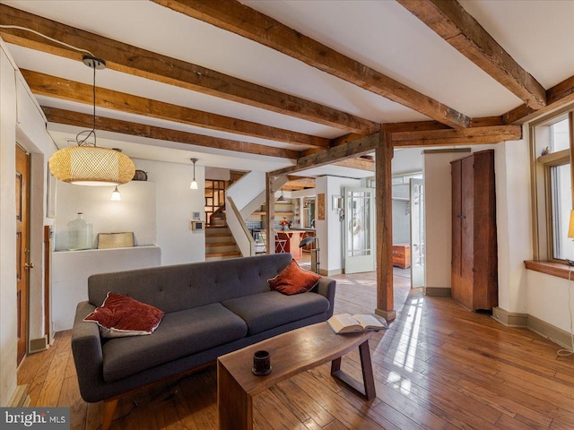 living room featuring beamed ceiling and light hardwood / wood-style floors