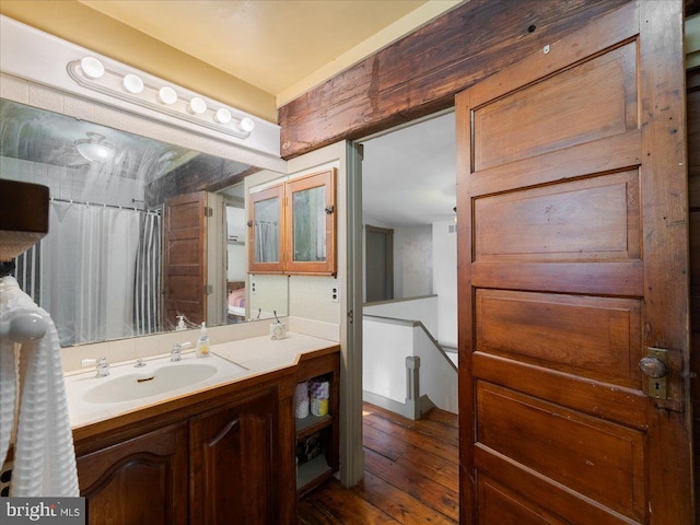 bathroom featuring walk in shower, vanity, and hardwood / wood-style flooring