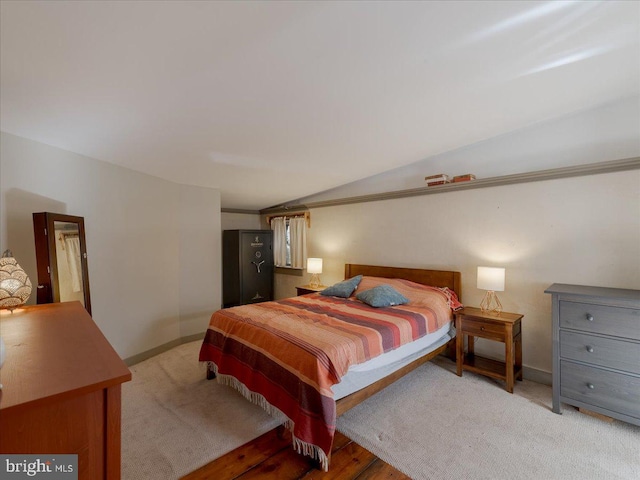 bedroom featuring light hardwood / wood-style flooring and vaulted ceiling