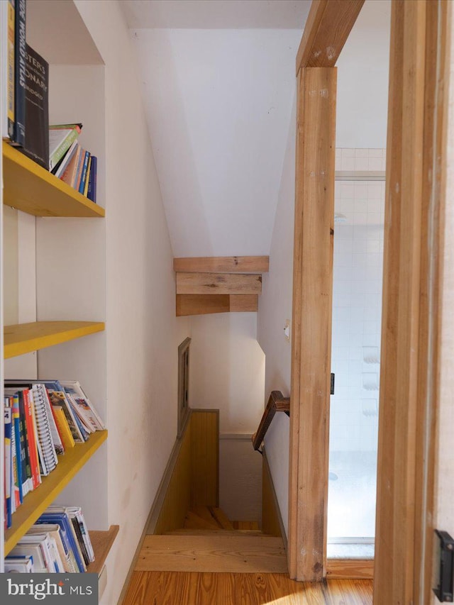 stairway featuring lofted ceiling and hardwood / wood-style floors