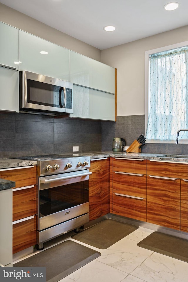 kitchen featuring appliances with stainless steel finishes, plenty of natural light, sink, and tasteful backsplash