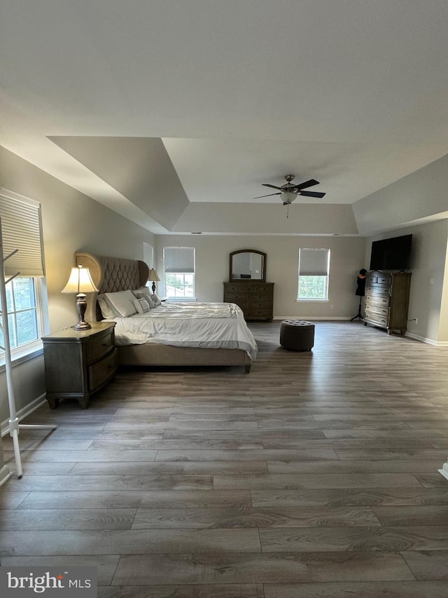 unfurnished bedroom with ceiling fan, light wood-type flooring, and multiple windows