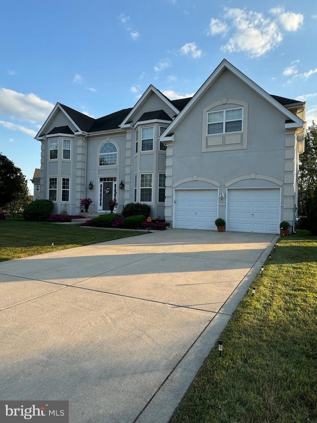 view of property featuring a front yard and a garage