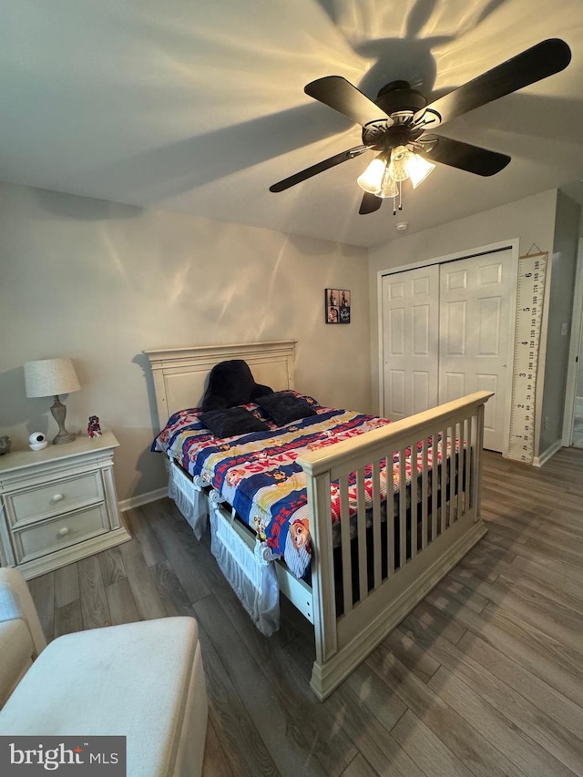 bedroom with dark wood-type flooring, a closet, and ceiling fan