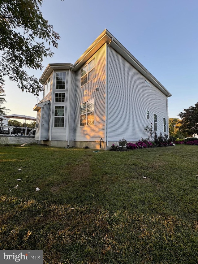 property exterior at dusk with a yard