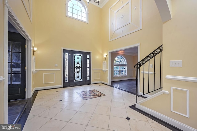 foyer with a towering ceiling, ornamental molding, and a healthy amount of sunlight