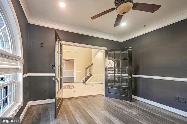 foyer entrance featuring ceiling fan, crown molding, wood-type flooring, and a wealth of natural light