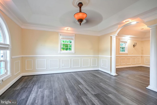 spare room featuring ornate columns, a healthy amount of sunlight, crown molding, and dark hardwood / wood-style floors