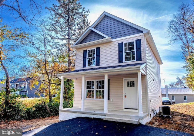 view of front of home with a porch and central AC unit