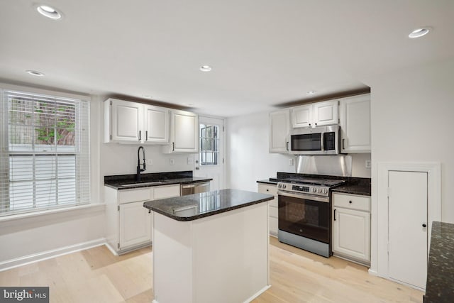 kitchen featuring light wood-type flooring, white cabinetry, a center island, and stainless steel appliances