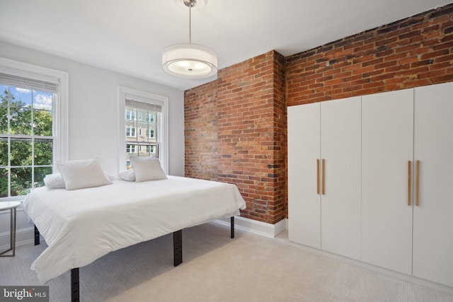 carpeted bedroom featuring brick wall