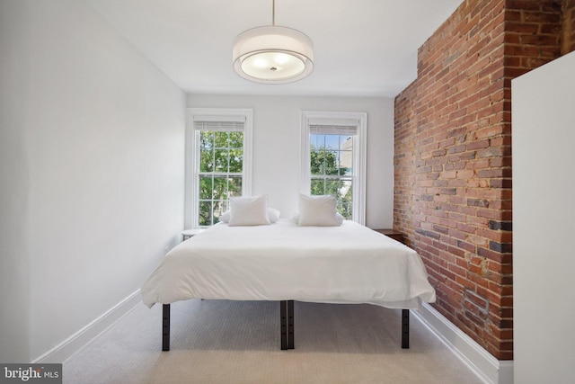 bedroom featuring brick wall and light colored carpet