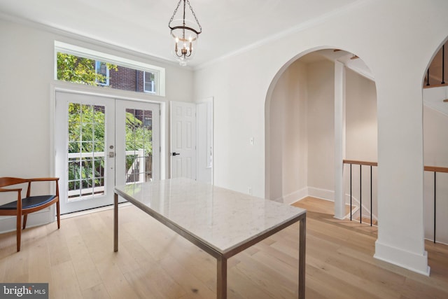 home office featuring french doors, ornamental molding, light wood-type flooring, and a chandelier