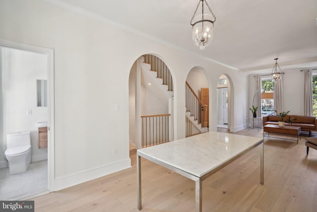 dining room featuring ornamental molding, a notable chandelier, and light hardwood / wood-style floors